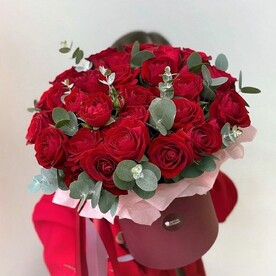 Алые кустовые розы в шляпной коробке