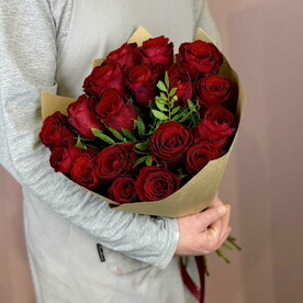 Букет из бордовых роз с зеленью в крафте
